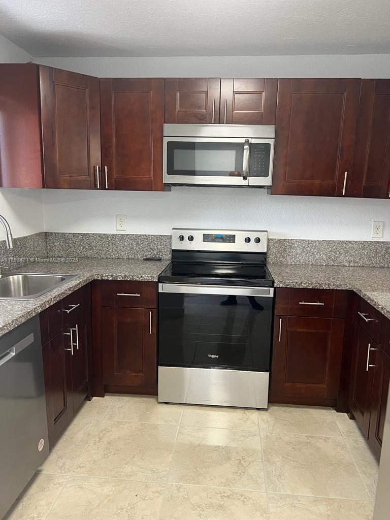 2670 West 76th Street, Unit 101 Hialeah, FL 33016 - Photo 9 of 35 a kitchen with granite countertop a stove and a microwave