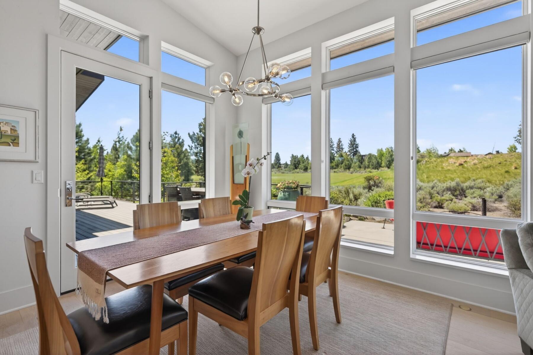 61487 Hackleman Court Bend, OR 97702 - Photo 15 of 35 a view of a dining room with furniture large windows and wooden floor