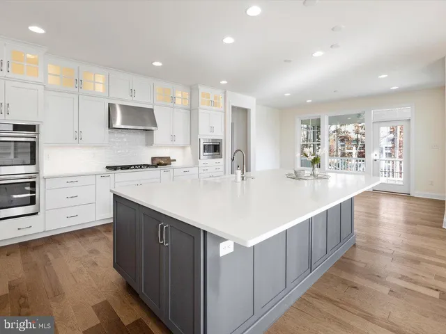 a kitchen with stainless steel appliances kitchen island a cabinets and wooden floor