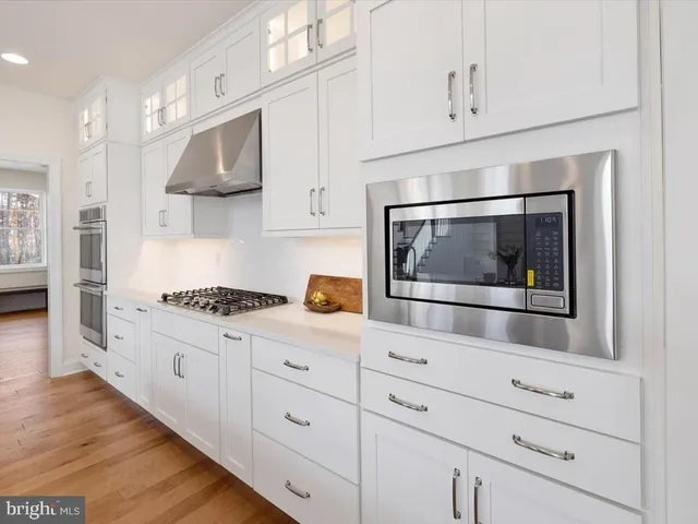 a kitchen with white cabinets and appliances
