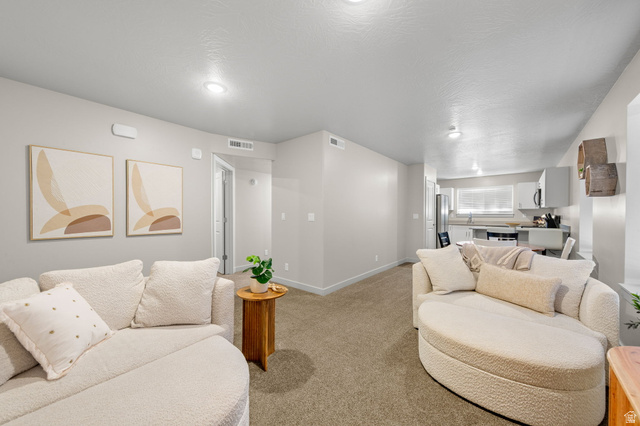 6231 Winding Way, Unit K105 Hurricane, UT 84737 - Photo 5 of 20 Living area with light colored carpet and baseboards