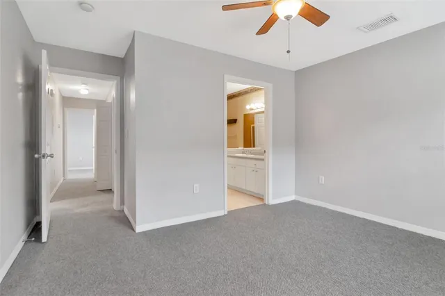 a sign that is sitting in front of a house with potted plants