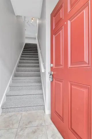 a view of empty room with wooden floor and kitchen