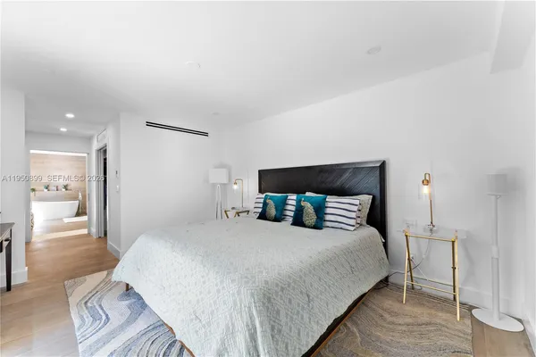 a bedroom with a bed a mirror and a table