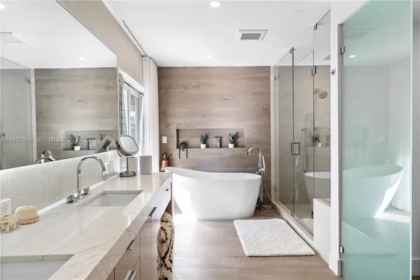 a bathroom with a tub sink and mirror
