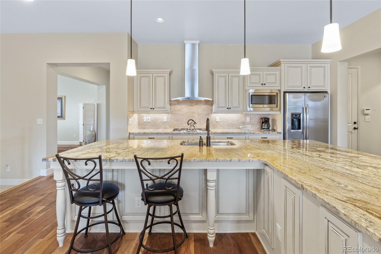 49 Willowcroft Drive Littleton, CO 80123 - Photo 4 of 47 a kitchen with kitchen island granite countertop wooden floor cabinets and chairs