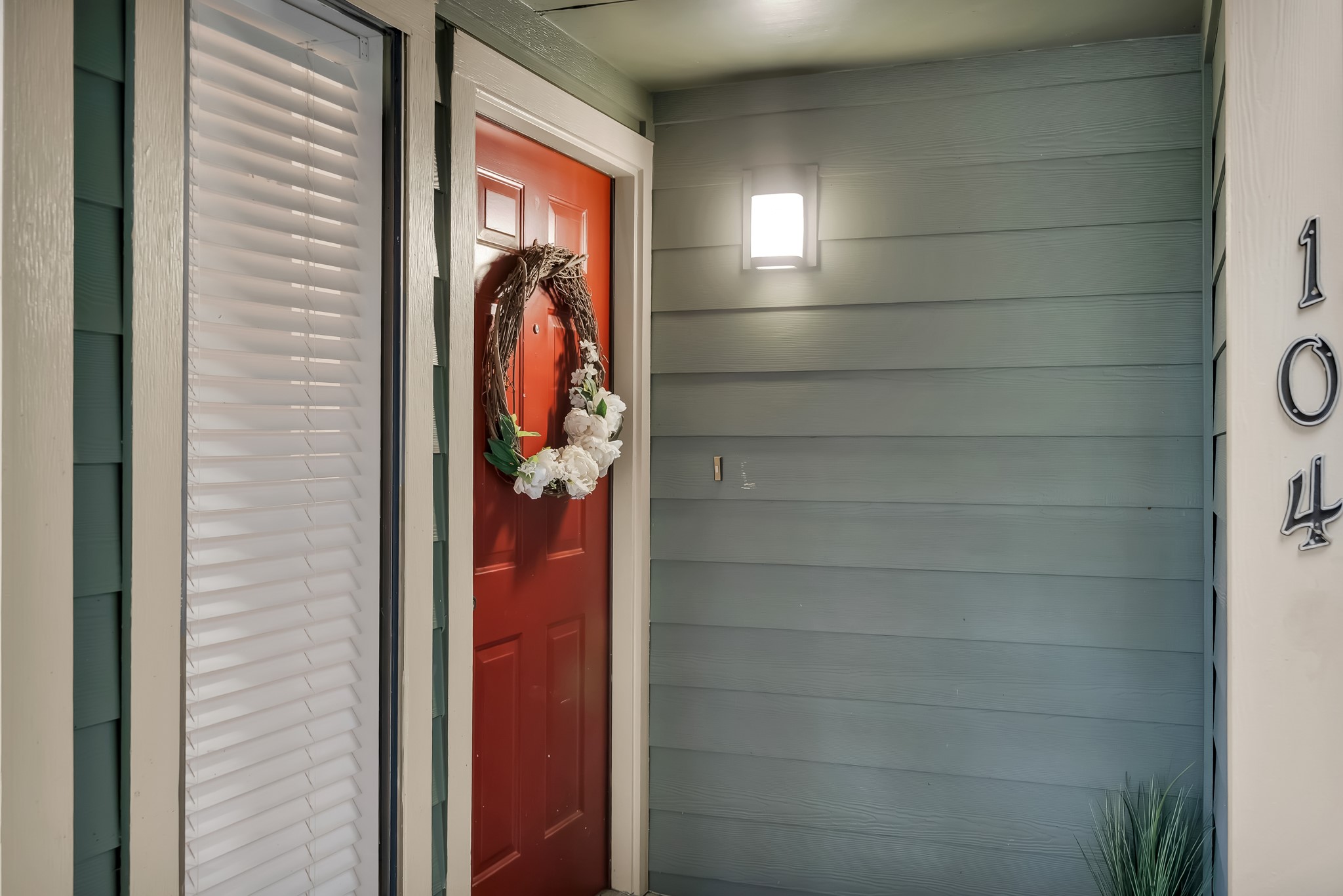 11970 Jollyville Road, Unit 104 Austin, TX 78759 - Photo 18 of 22 Welcoming entrance featuring a red door, outdoor lighting, and side panel with blinds