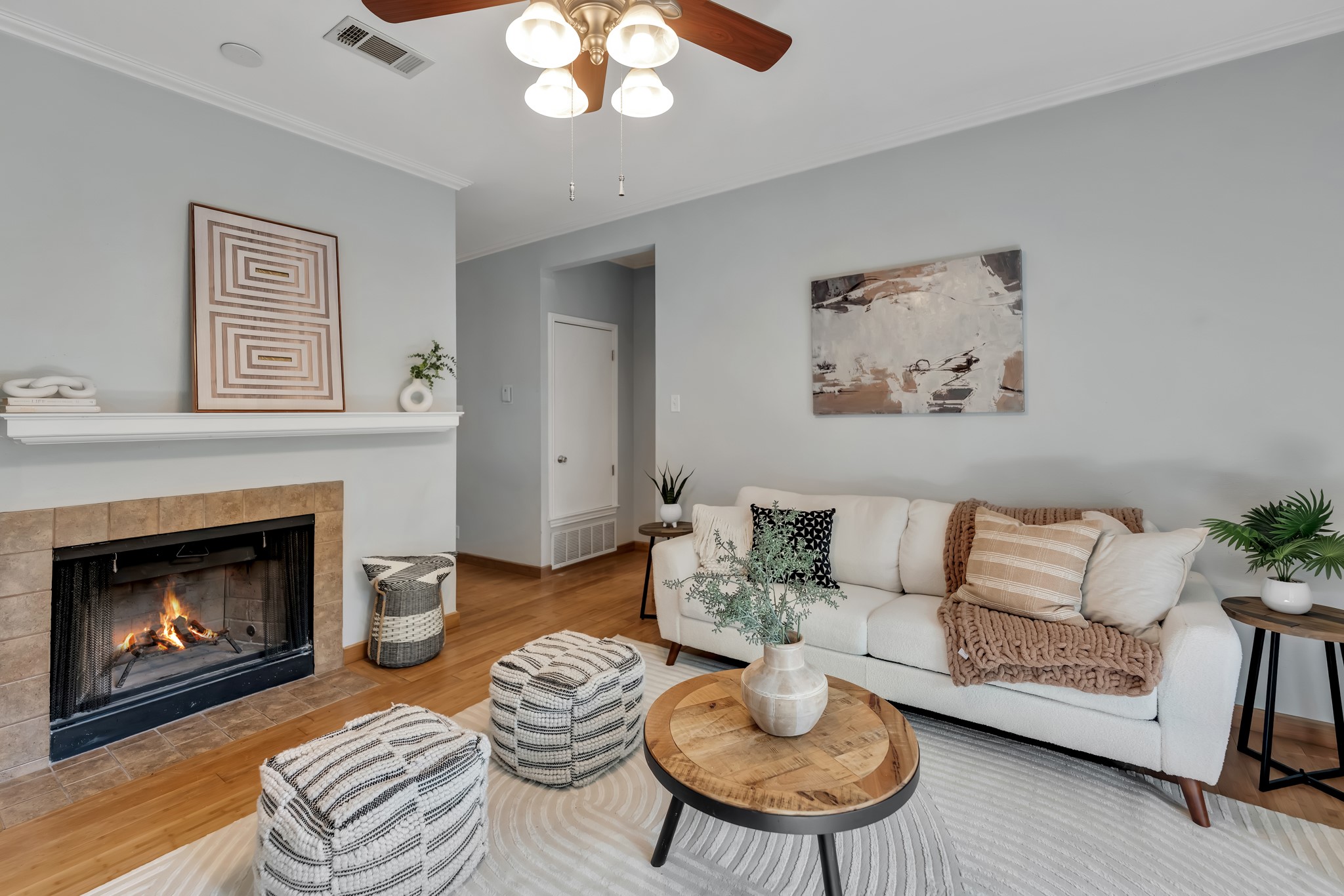 11970 Jollyville Road, Unit 104 Austin, TX 78759 - Photo 2 of 22 Living area featuring hardwood floors, a tiled fireplace with mantel, and a ceiling fan