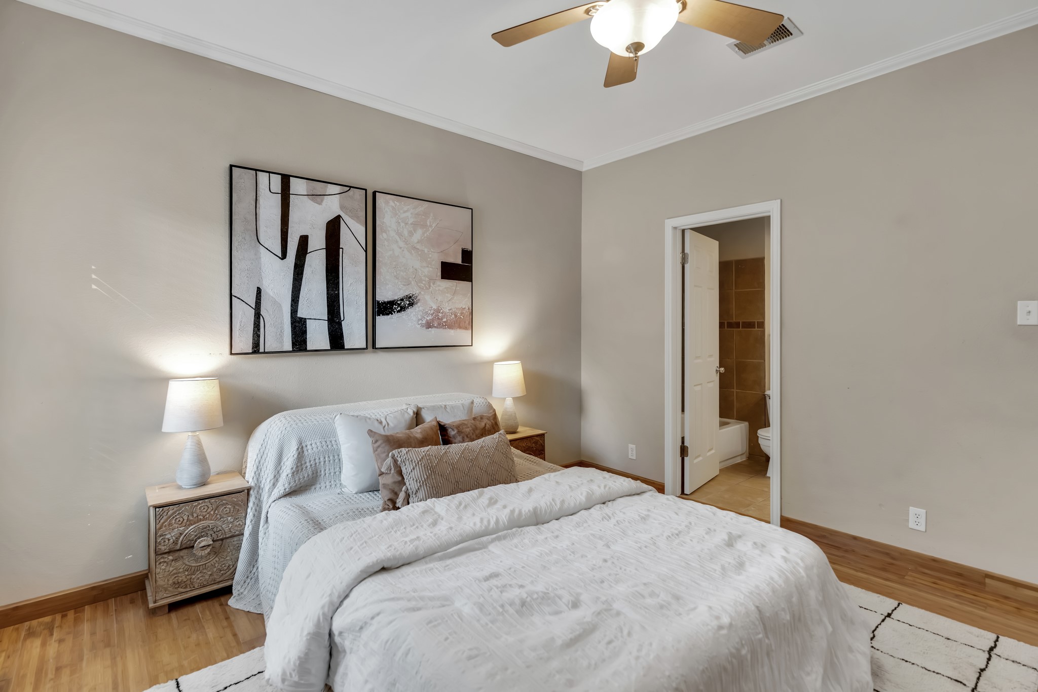 11970 Jollyville Road, Unit 104 Austin, TX 78759 - Photo 9 of 22 This bedroom features hardwood floors, a ceiling fan, and crown molding