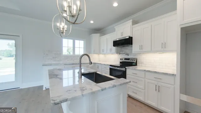 a kitchen with granite countertop white cabinets and black appliances