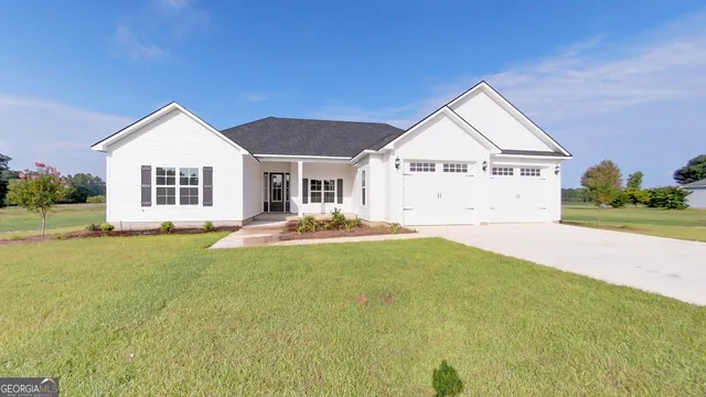 a view of a house with a big yard and large trees