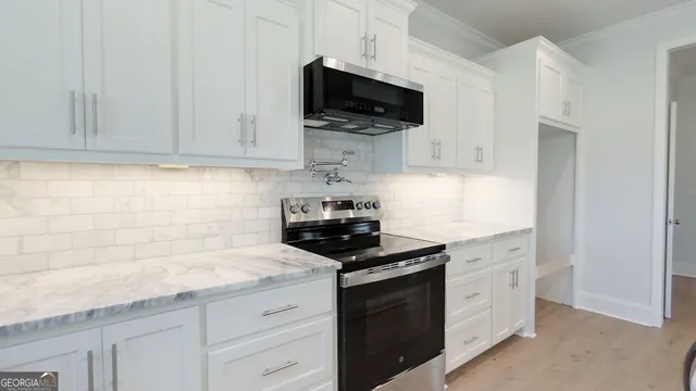 a kitchen with stainless steel appliances granite countertop a stove and a microwave