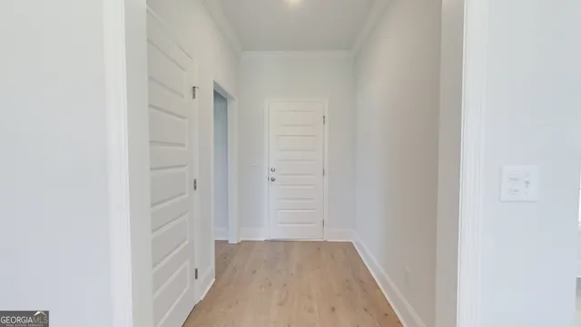 an empty room with chandelier fan and windows