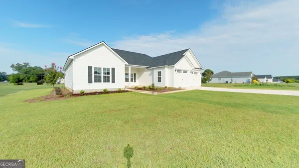 a front view of a house with a yard and trees