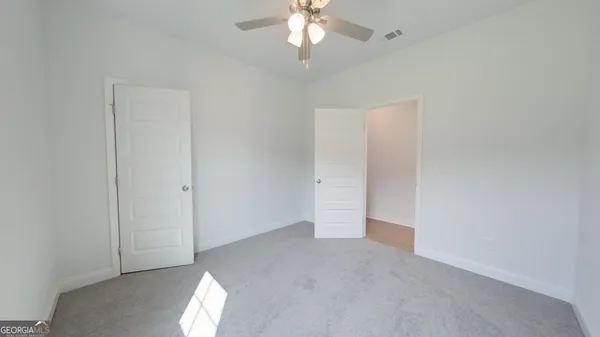 an empty room with a window and a fan