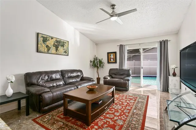 a living room with furniture ceiling fan and a window