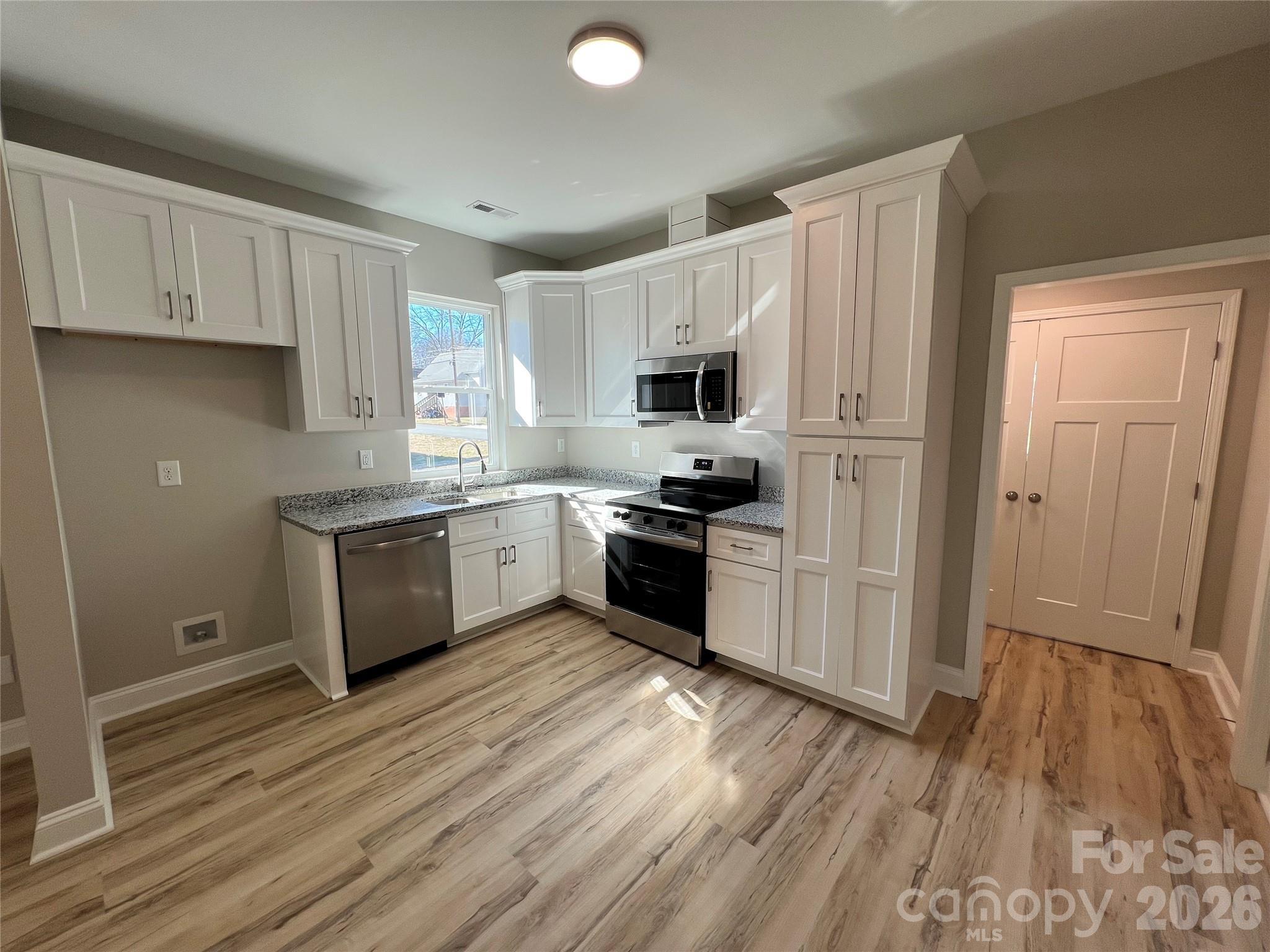 722 Austin Street Albemarle, NC 28001 - Photo 12 of 22 a kitchen with kitchen island granite countertop a sink cabinets and stainless steel appliances