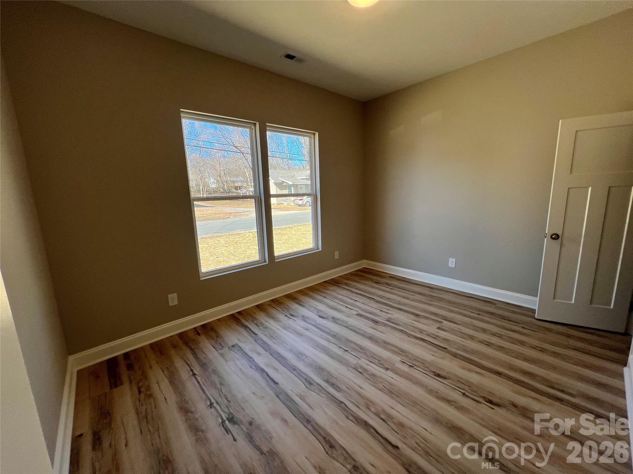 722 Austin Street Albemarle, NC 28001 - Photo 13 of 22 a view of an empty room with wooden floor and a window