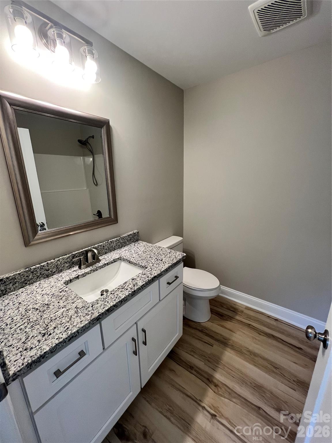 722 Austin Street Albemarle, NC 28001 - Photo 15 of 22 a bathroom with a granite countertop toilet sink and mirror