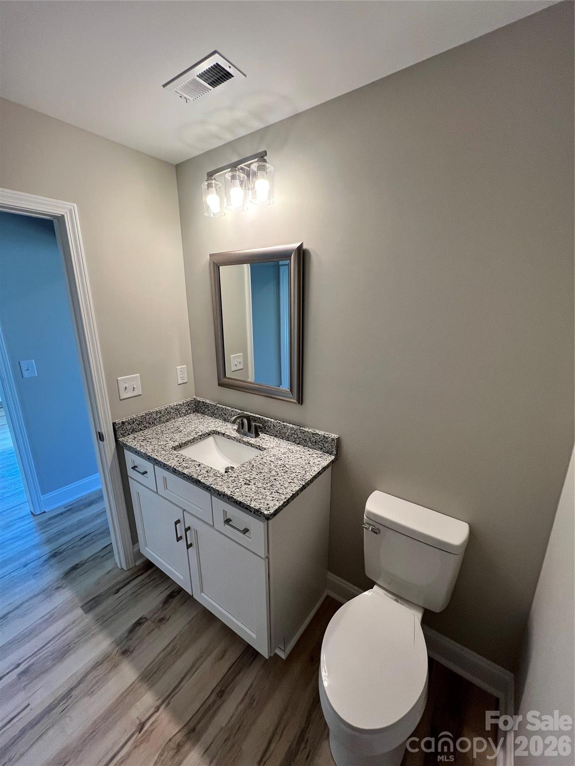 722 Austin Street Albemarle, NC 28001 - Photo 16 of 22 a bathroom with a granite countertop toilet sink and mirror