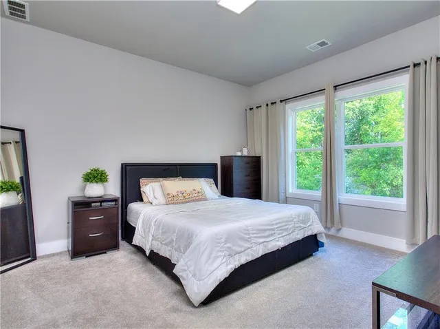 a bedroom with a bed and a large window