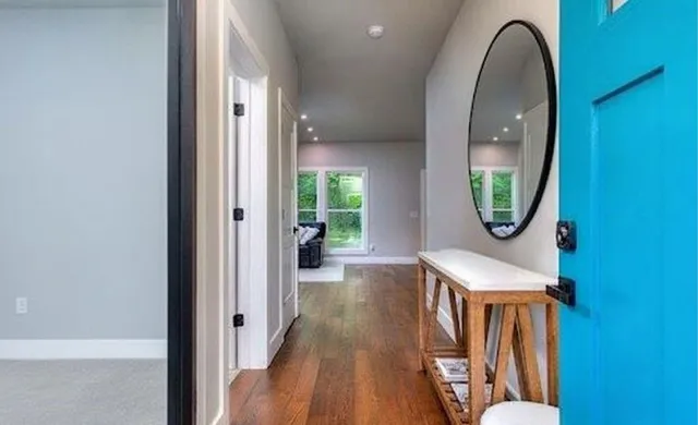 an entryway with wooden floor mirror and a sink