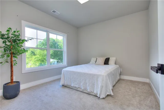 a spacious bedroom with a bed and a window