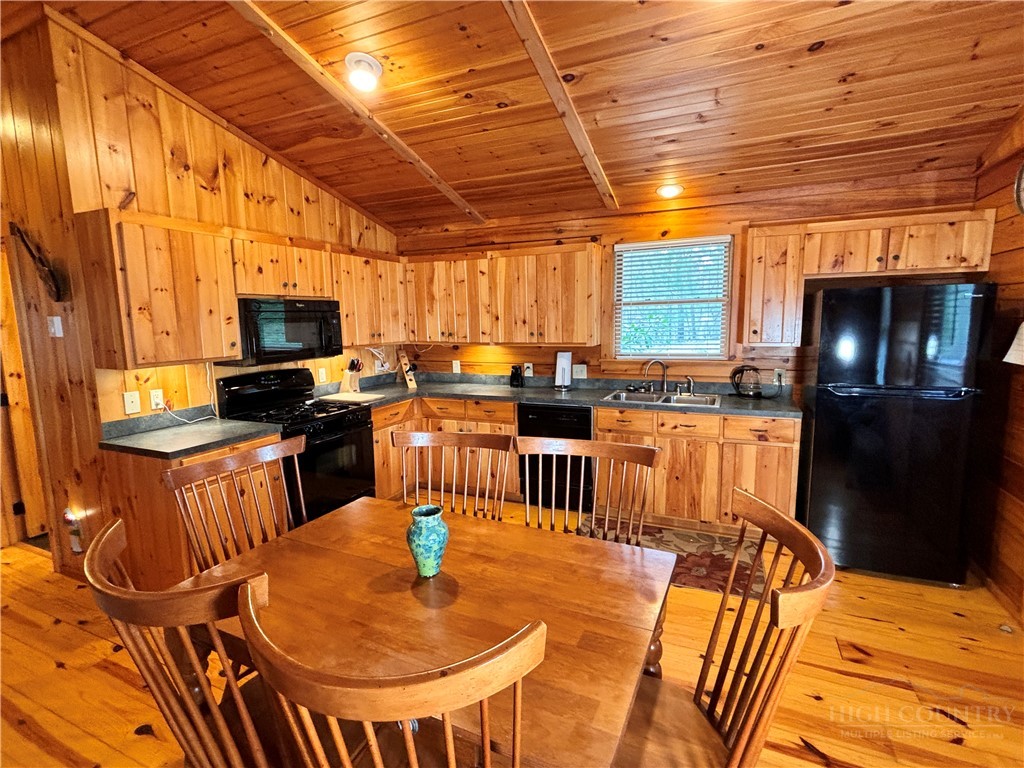 150 Turkey Ridge Crumpler, NC 28617 - Photo 25 of 40 a kitchen with stainless steel appliances kitchen island granite countertop a table chairs and a wooden cabinets
