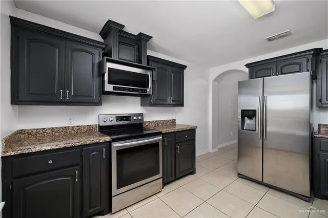 a kitchen with stainless steel appliances granite countertop a stove microwave and refrigerator
