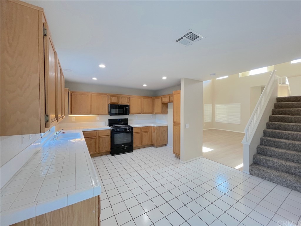 651 Pointe Vista Lane Corona, CA 92881 - Photo 6 of 19 a large white kitchen with a stove a sink and a refrigerator