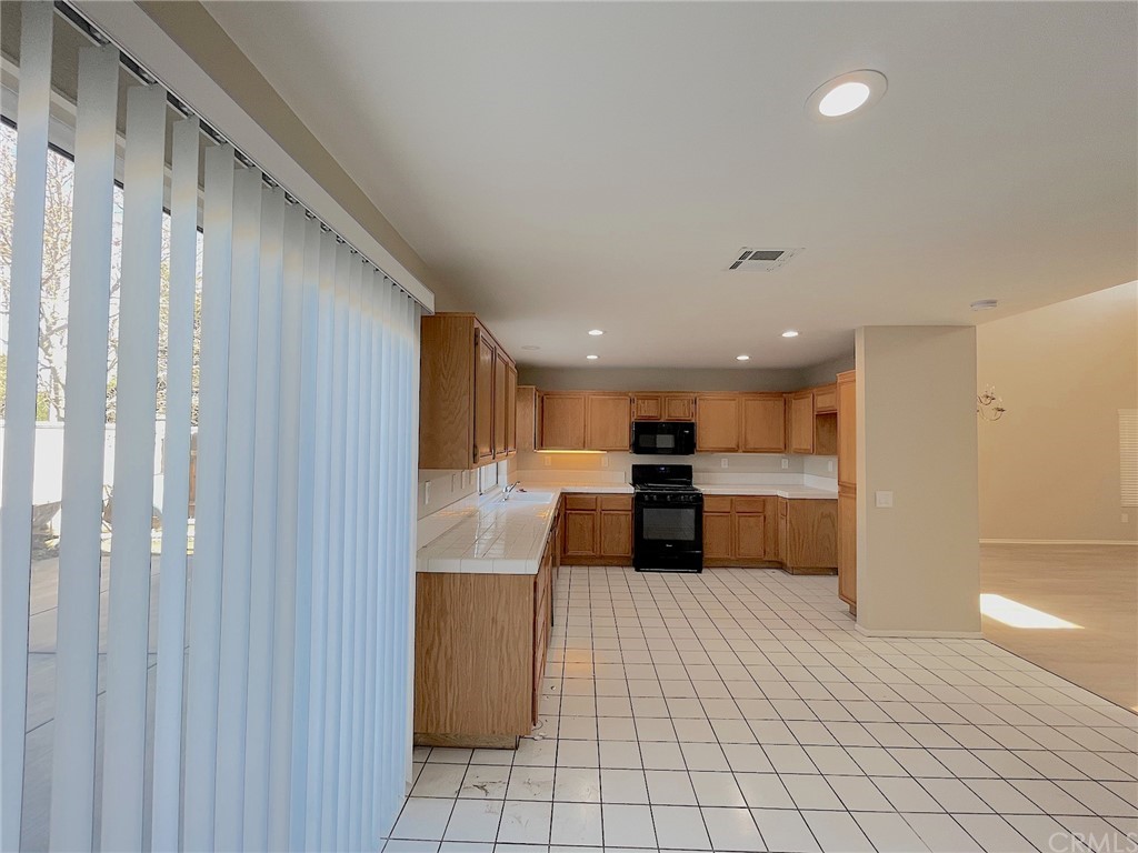 651 Pointe Vista Lane Corona, CA 92881 - Photo 7 of 19 a large white kitchen with a cabinetry and a potted plant
