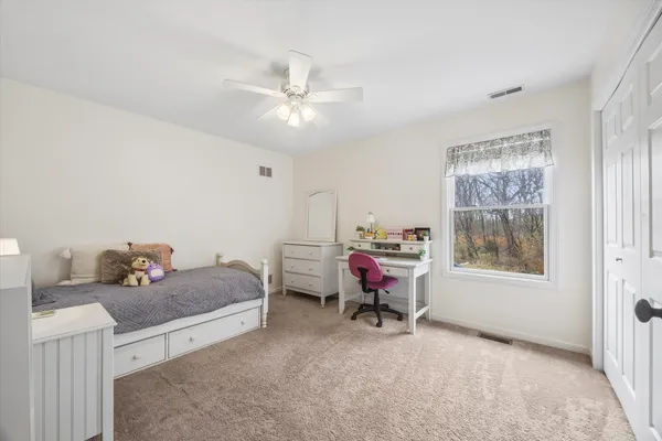 a spacious bedroom with a bed couch and window