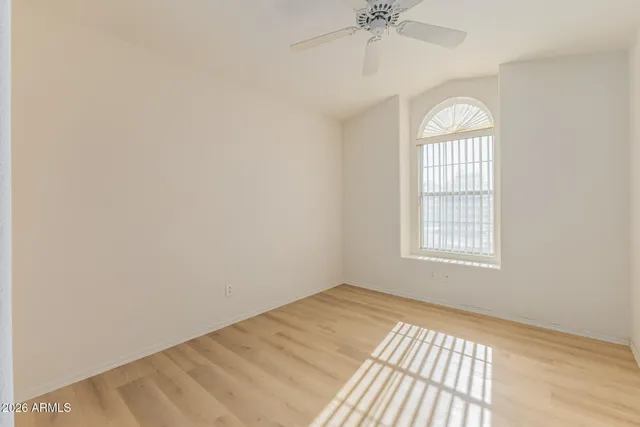 a view of a room with wooden floor and a ceiling fan