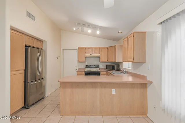 a large kitchen with stainless steel appliances granite countertop a refrigerator a sink and a stove