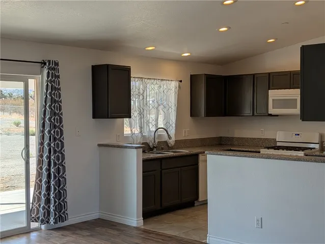 a kitchen with stainless steel appliances granite countertop a sink and a stove top oven