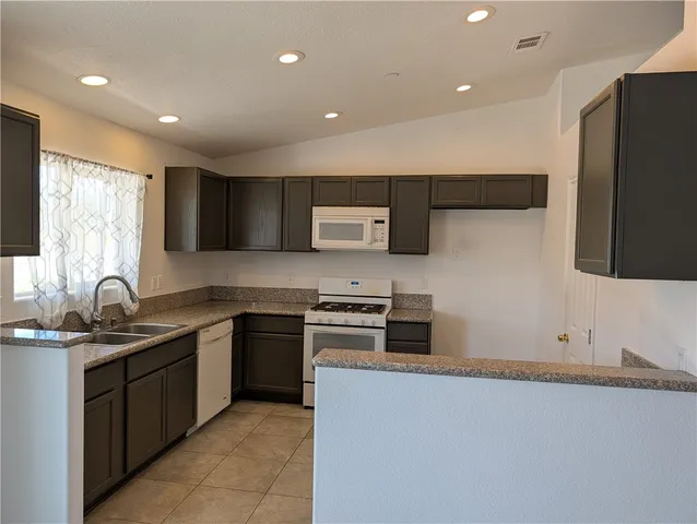 a kitchen with stainless steel appliances granite countertop a sink and a stove