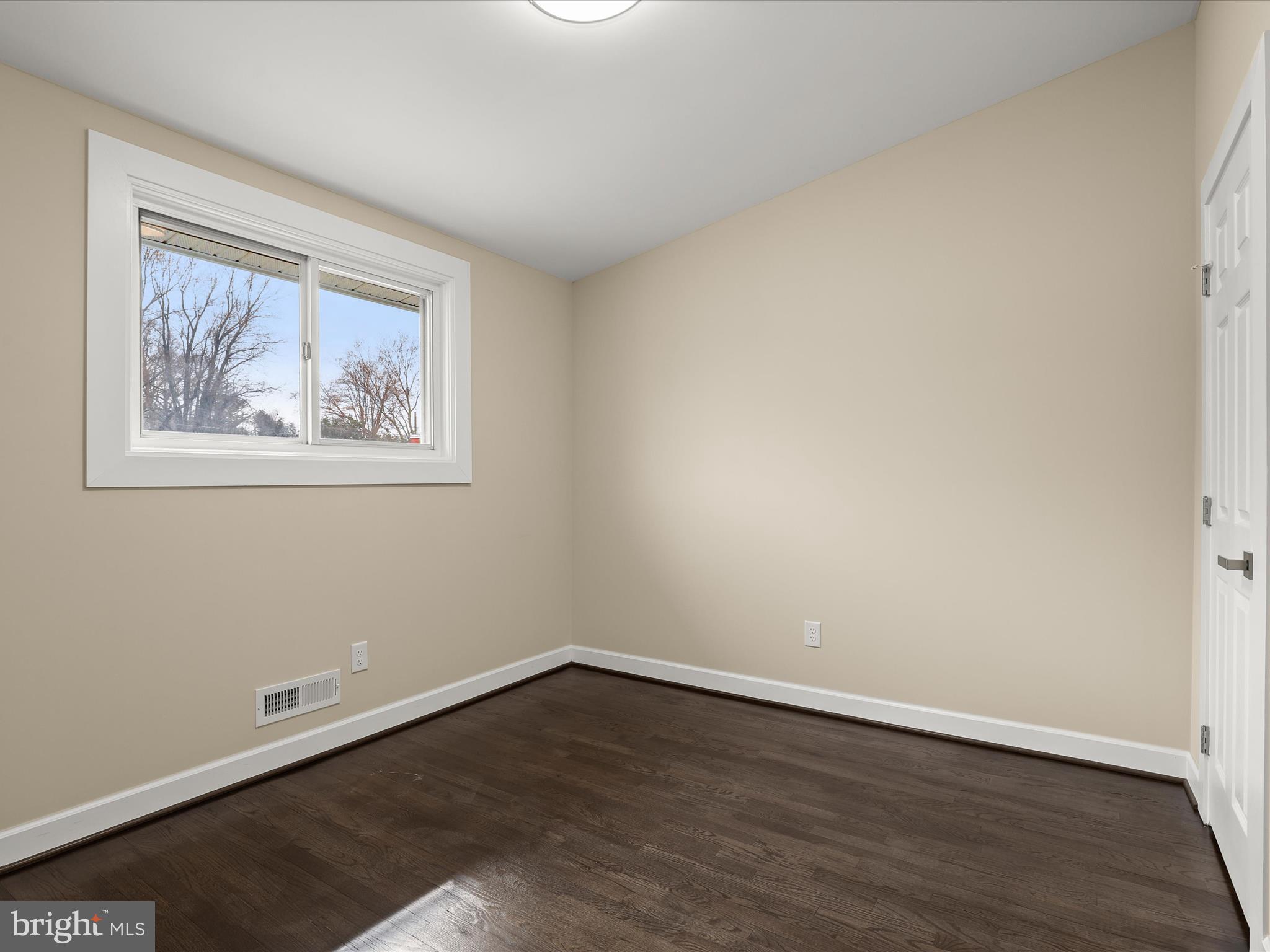 4708 Maryknoll Road Baltimore, MD 21208 - Photo 21 of 44 a view of an empty room with wooden floor and a window