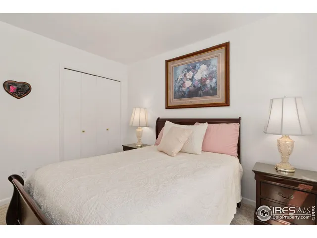 a bedroom with a bed and a lamp on dresser