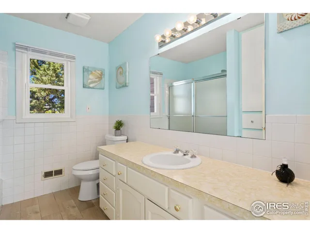 a bathroom with a sink a toilet and mirror