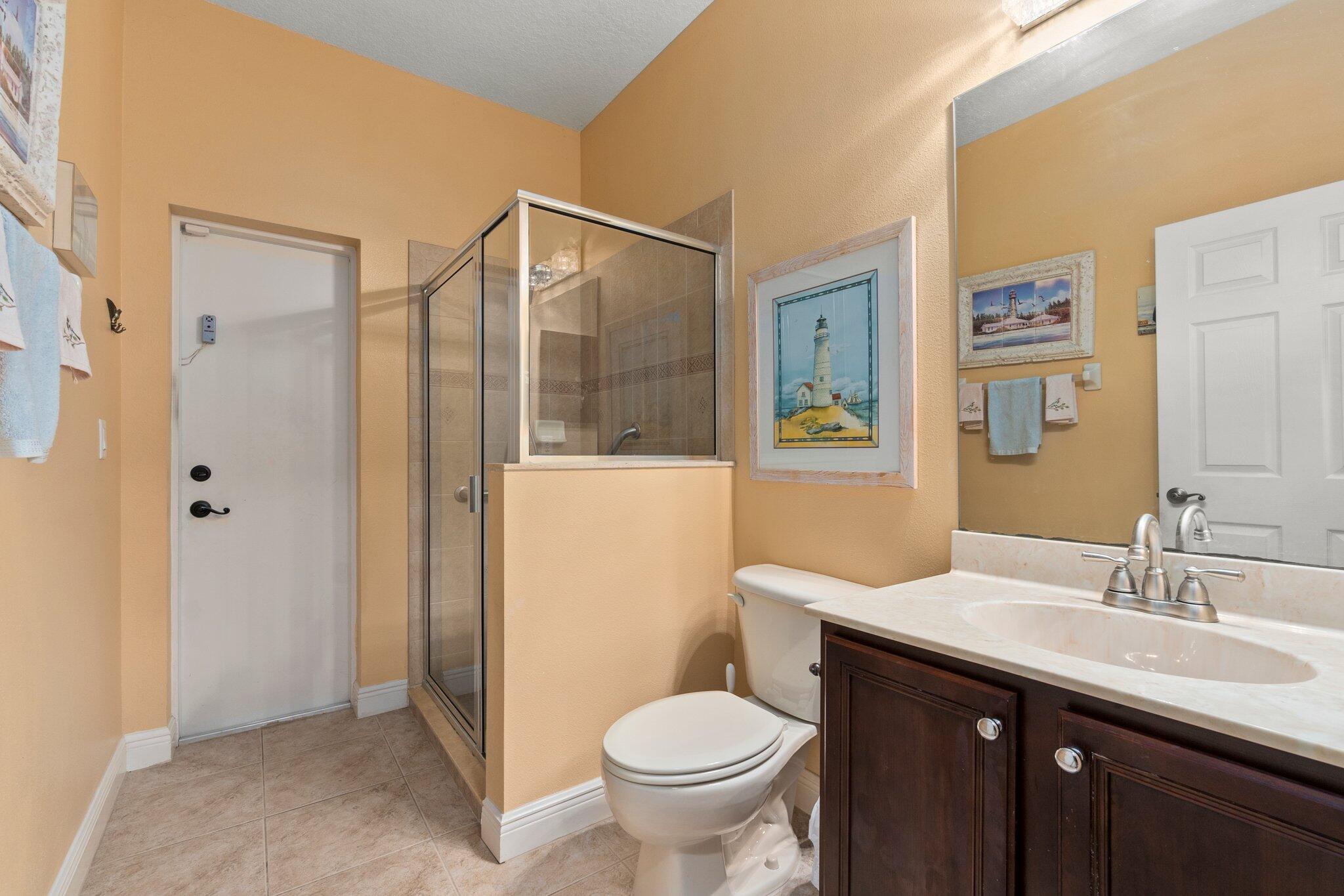 2309 Southwest Ivory Road Port St. Lucie, FL 34953 - Photo 18 of 46 a bathroom with a granite countertop toilet sink and shower