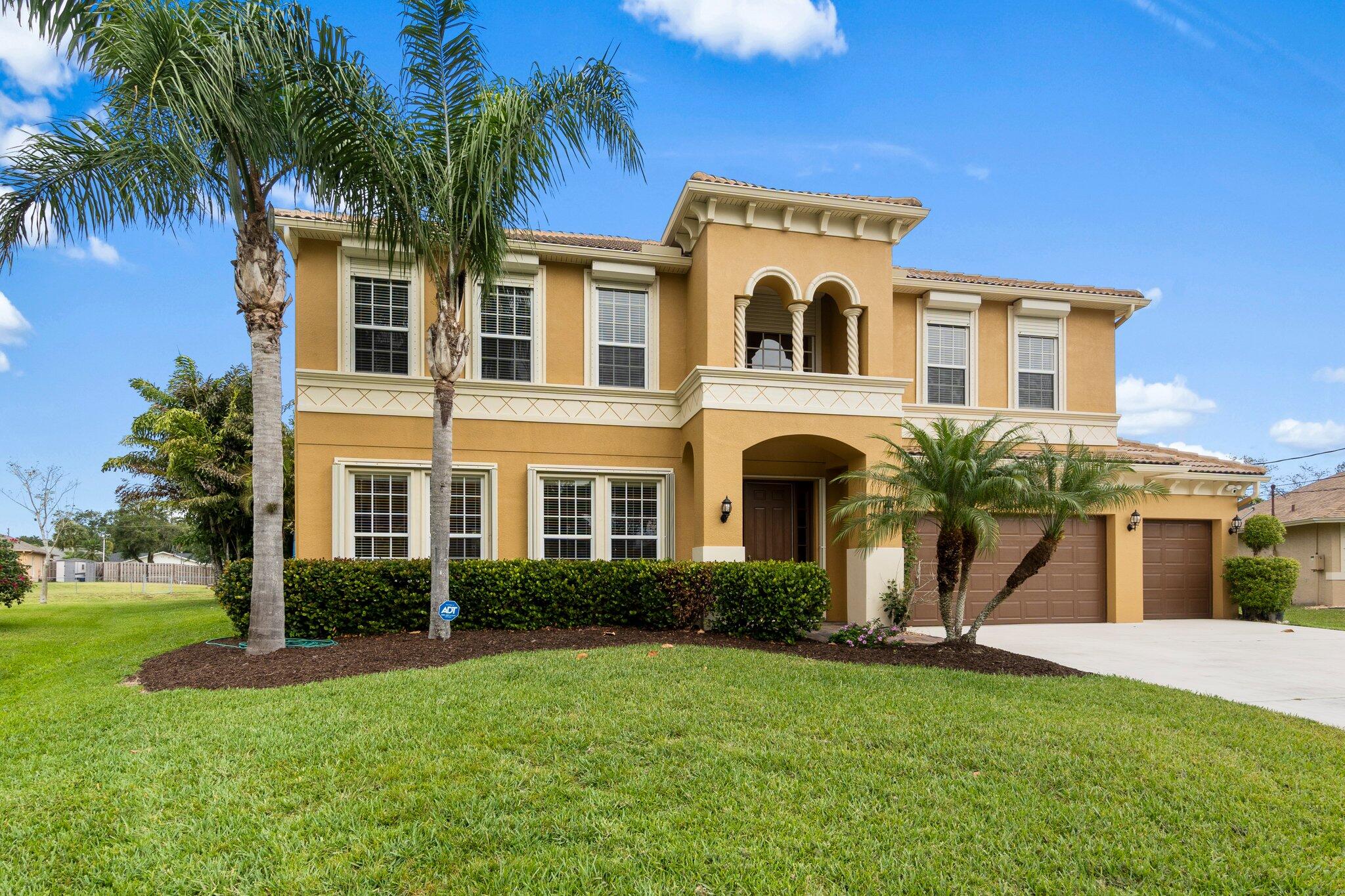 2309 Southwest Ivory Road Port St. Lucie, FL 34953 - Photo 2 of 46 a front view of a house with a yard