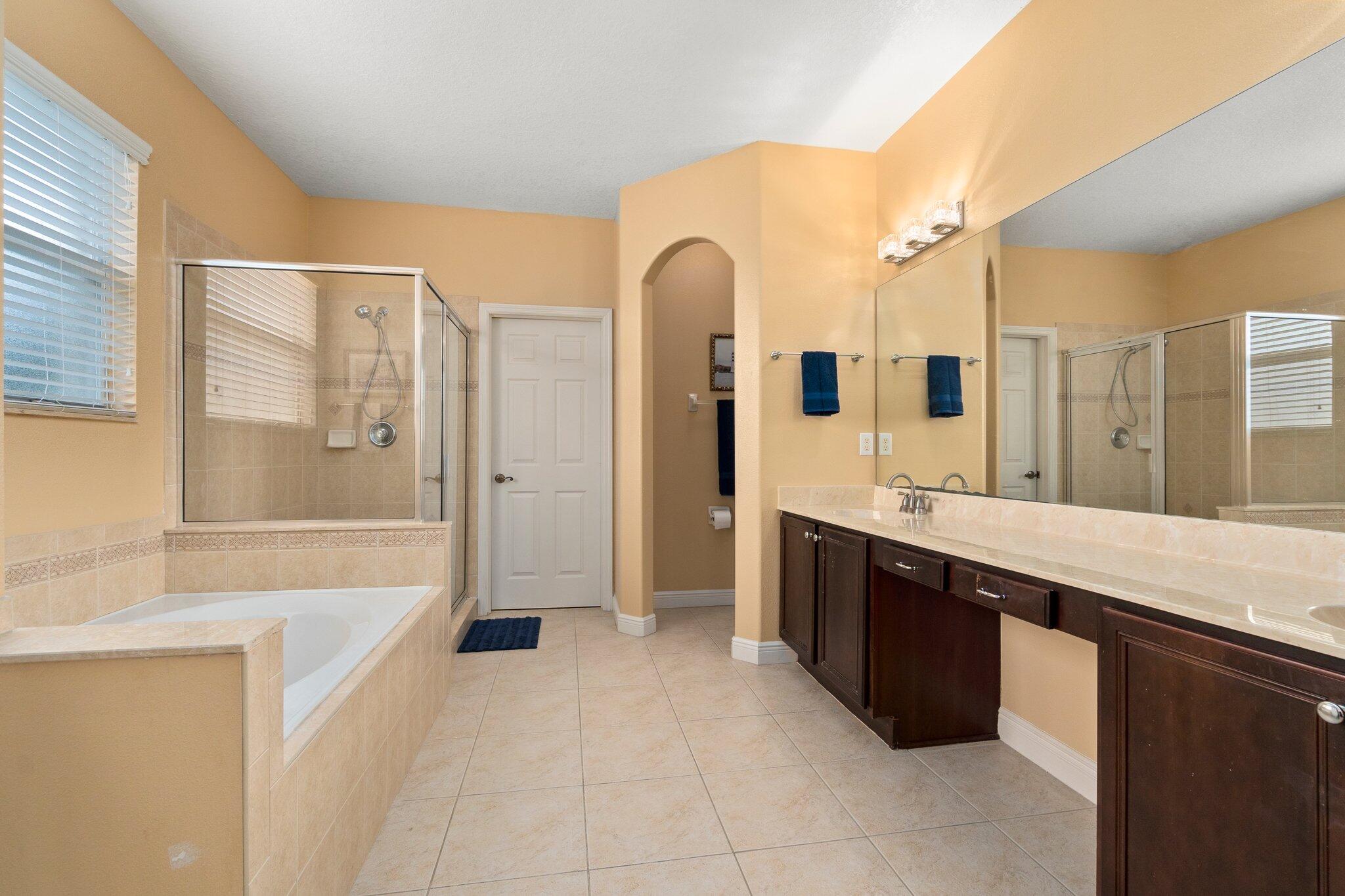 2309 Southwest Ivory Road Port St. Lucie, FL 34953 - Photo 26 of 46 a spacious bathroom with a bathtub sink and mirror