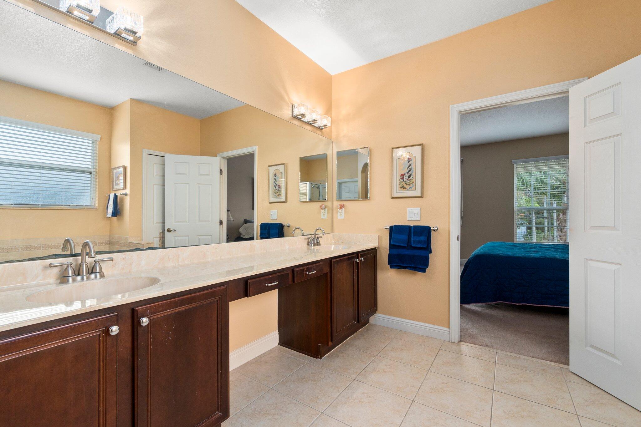 2309 Southwest Ivory Road Port St. Lucie, FL 34953 - Photo 28 of 46 a spacious bathroom with a granite countertop sink and a mirror