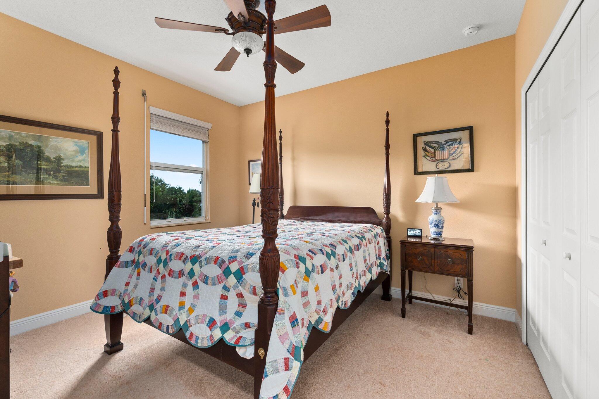2309 Southwest Ivory Road Port St. Lucie, FL 34953 - Photo 30 of 46 a bedroom with a bed and a chandelier