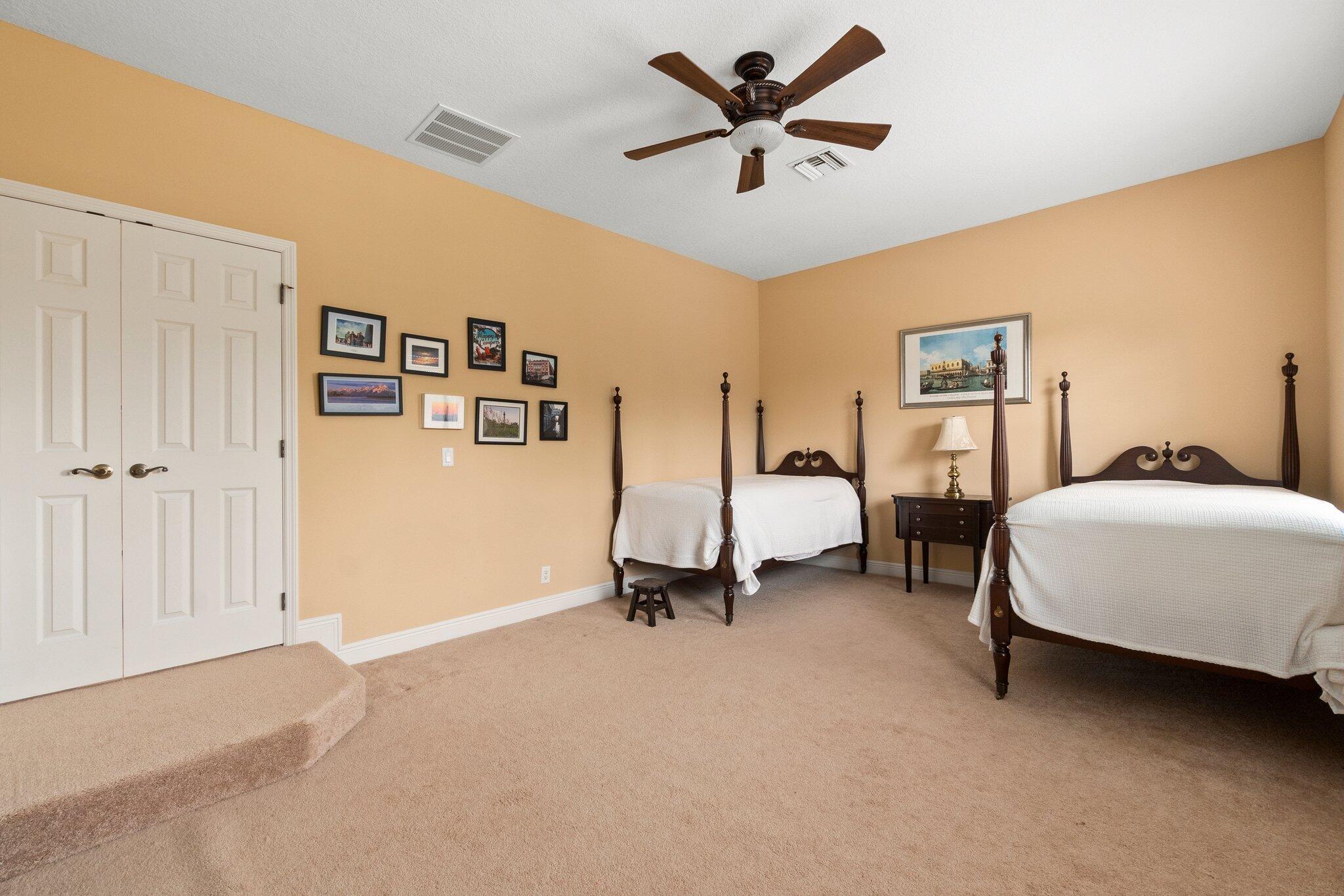 2309 Southwest Ivory Road Port St. Lucie, FL 34953 - Photo 34 of 46 a bedroom with bed and a chandelier