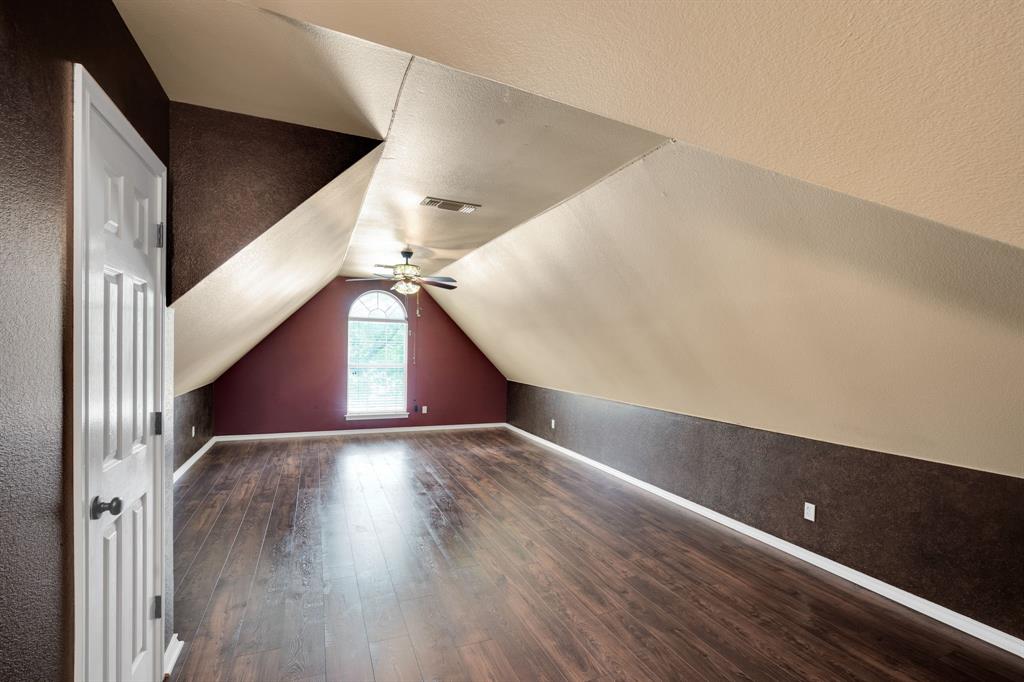 1907 Timber Ridge Court Cedar Hill, TX 75104 - Photo 19 of 30 Spacious room featuring wood-finish flooring, a ceiling fan, and an arched window