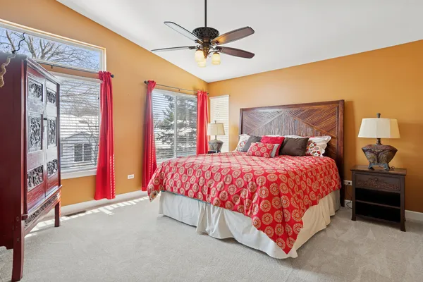 a spacious bedroom with a bed and a chandelier
