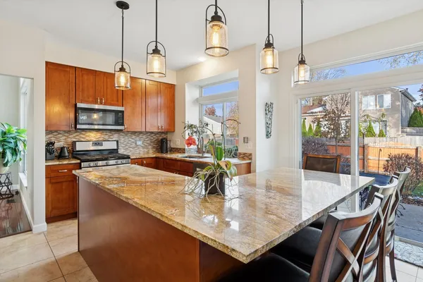 a kitchen with stainless steel appliances granite countertop a sink a stove and a refrigerator