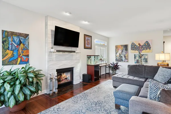a living room with furniture a flat screen tv and a fireplace