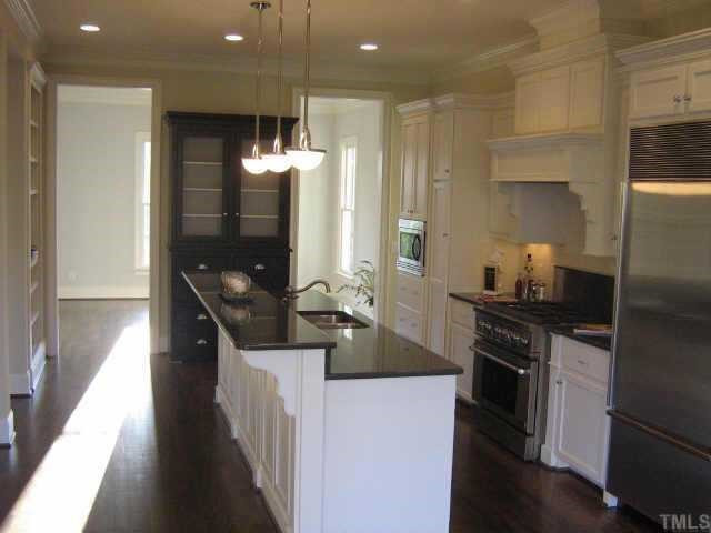 3210 Rain Forrest Way Raleigh, NC 27614 - Photo 5 of 12 Kitchen features a built in sub zero refrigerator, all oak flooring, gas range, hood exhaust, built-in hutch, 2 separate floor to ceiling shelf areas for small appliances or books, microwave/convection oven and dishwasher. Kitchen